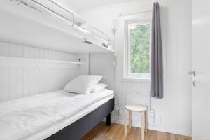 a small bedroom with a bed and a stool at First Camp Nydala-Umeå in Umeå