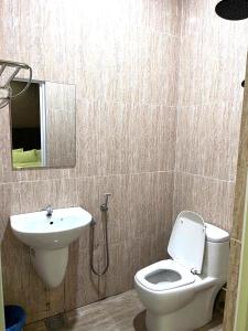 a bathroom with a toilet and a sink at Hotel Sagittario in Ipoh