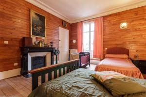 a bedroom with wood paneling and a bed and a fireplace at Bonjour Guesthouse in Nevers