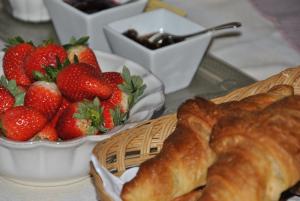 una mesa con una cesta de fresas y un cruasán en Maison d'hôtes Urbegia en Ascain