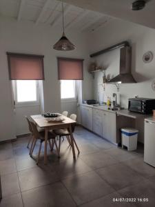 a kitchen with a table and chairs in a room at Smyrnis Apartments in Ermoupoli