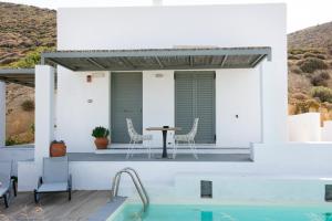 ein Haus mit einem Pool, einem Tisch und Stühlen in der Unterkunft Villa Lino in Skyros