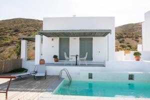 Biały dom z basenem i stołem w obiekcie Villa Lino w mieście Skiros