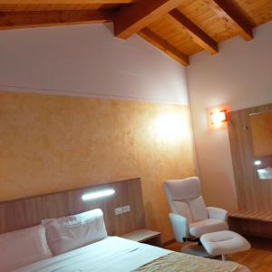 een slaapkamer met een bed en een stoel bij Al Cavaliere in Pordenone