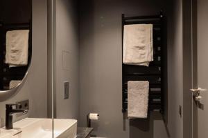 a bathroom with a sink and a mirror and towels at Kalnu dzīvoklis (The hill condo) in Cēsis