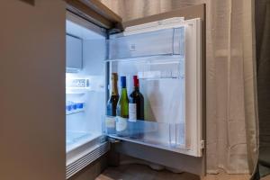 an open refrigerator with bottles of wine in it at Kalnu dzīvoklis (The hill condo) in Cēsis +13 photos