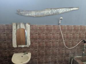 ein Badezimmer mit Spiegel und Waschbecken in der Unterkunft C Point Krui in Krui