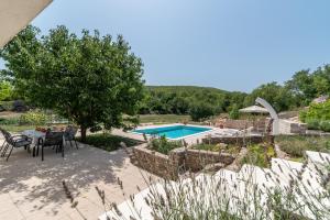 a patio with a table and chairs and a swimming pool at Villa Bacio with new heated pool in Brštanovo