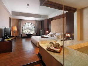 a large hotel room with a bed and a television at Grand City Hall Hotel & Serviced Residences in Medan