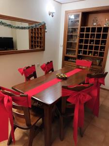 un comedor con una mesa de madera con arcos rojos en Guest house "The House", en Zlatograd