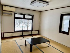 Habitación con mesa frente a una ventana en 19 Accommodation, en Hachimantai