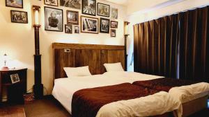 金澤的住宿－ダイアナ，卧室配有一张床,墙上挂有图片