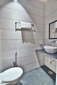 a bathroom with a white toilet and a sink at Hotel Singh International, Amritsar in Amritsar