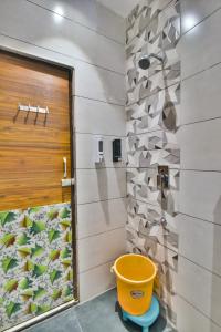 a bathroom with a shower and a yellow bucket at Hotel Singh International, Amritsar in Amritsar