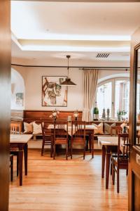 Hotel Hofwirt Neubeuern في نيوبيورن: غرفة طعام مع طاولة وكراسي