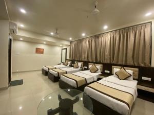 a room with four beds and a glass table at HOTEL ANNAPURNA in Vishnupur