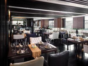 a restaurant with tables and chairs in a room at Grand City Hall Hotel & Serviced Residences in Medan