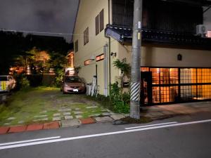 um carro estacionado ao lado de um edifício numa rua em 小京都の宿 へうたん em Nishio