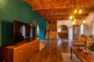 a living room with green walls and a large television at Holiday home Palo santo in Gospić