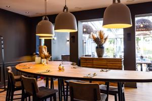 restauracja z dużym drewnianym stołem i krzesłami w obiekcie The Oceans w mieście Timmendorfer Strand
