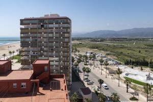 a tall building next to a beach with a parking lot at LIDER, 12º-A Atico in Cullera