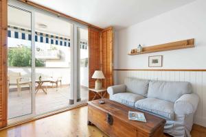 シッチェスにあるCentral a 10 minutos de la payaのソファとテーブルのあるリビングルーム +2枚の写真