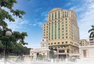 wysoki budynek z wieżą zegarową przed nim w obiekcie Grand City Hall Hotel & Serviced Residences w mieście Medan