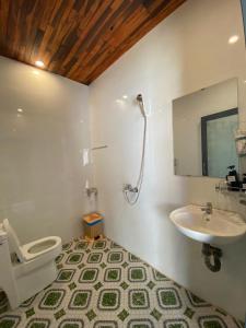 a bathroom with a toilet and a sink at Rice straw Green lodge- resort in Quan Tom