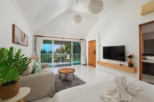 uma sala de estar com um sofá e uma televisão em Daydream villa resort em Praia de Patong