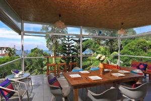 uma sala de jantar com mesa e cadeiras e uma grande janela em Daydream villa resort em Praia de Patong