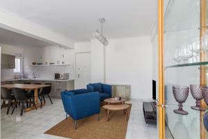 een woonkamer met blauwe stoelen en een tafel bij Elegant Apartment With Acropolis View in Athene