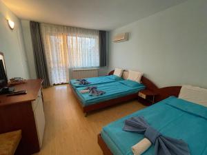 ein Hotelzimmer mit 2 Betten und einem Schreibtisch in der Unterkunft Bar & Guests room ELA in Dolen Bliznak