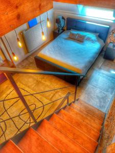 sypialnia z łóżkiem i schodami w pokoju w obiekcie L'accoté Chambre d'hotes La grange de Battignies w mieście Binche