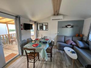 een woonkamer met een tafel en een bank bij Mobil Home Bleu ‘n’ Blue in Canet-en-Roussillon
