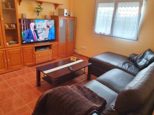 a living room with a couch and a tv at Casa César in Barreiros