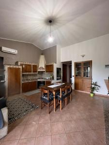 a living room with a table and a kitchen at CASA DEPAU in Tertenìa