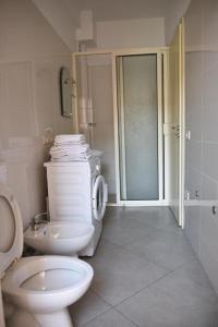 a white bathroom with a toilet and a sink at Hotel Shkodra L in Shkodër