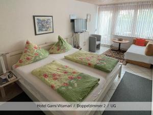 a room with a bed with two pillows on it at Hotel Garni Vitamari in Wasserburg