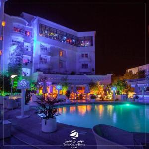 a large building with a swimming pool at night at Tunis Grand Hotel in Tunis