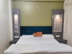a bedroom with a large bed with a blue headboard at Om Paradise Hotel in Ujjain Best Place to Stay near Mahakaleshwar Temple in Ujjain
