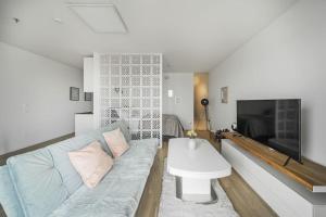 ein Wohnzimmer mit einem Sofa und einem TV in der Unterkunft City Sky Studio mit Balkon Vienna in Wien