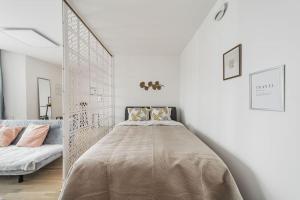 um quarto com uma cama grande num quarto branco em City Sky Studio mit Balkon Vienna em Viena