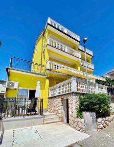 a yellow building with a balcony and a street light at Apartment Crikvenica, Vinodol 3 in Crikvenica