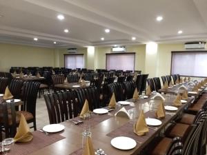 een grote kamer met tafels en stoelen. bij Hotel Sravasti Residency in Katra