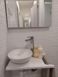 La salle de bains est pourvue d'un lavabo et d'un miroir. dans l'établissement Casa do Barqueiro - Porto - Quinta da Cabrida, à Porto