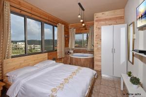 a bedroom with a large bed and a bath tub at צמרת הצימרים - מתחם צימרים מקסים עם בריכה במתחם וג'קוזי פרטי in Dāliyat el Karmil
