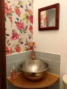 a sink in a bathroom with a flower wallpaper at JESMOND House B&B room 1 in Hull