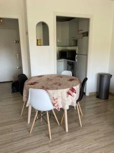 a dining room table with chairs and a kitchen at Appartement 2 pièces 6mn à pied du centre in Vence