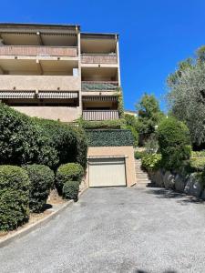 a building with a garage in front of a driveway at Appartement 2 pièces 6mn à pied du centre in Vence
