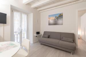ein Wohnzimmer mit einem Sofa und einem Tisch in der Unterkunft Palazzetto Vittoria - F&L Apartment in Brescia